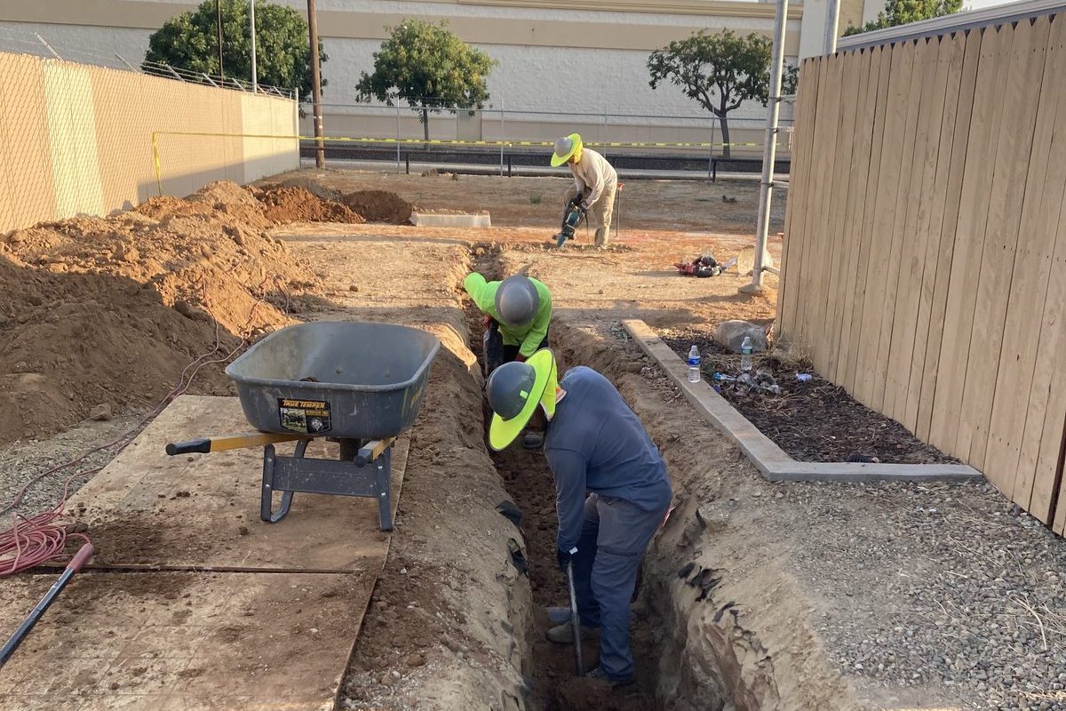 JMES crew performing trenching work for underground conduit installation
