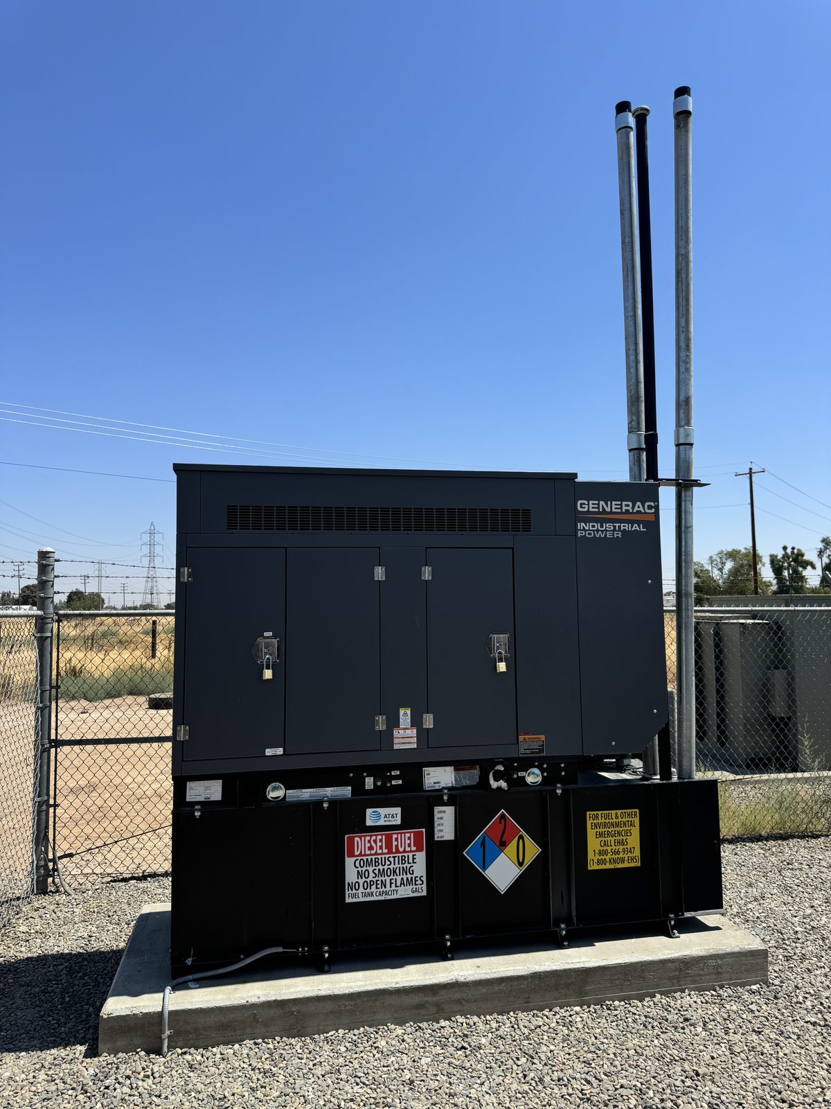 Backup generator installation under blue sky at a commercial site